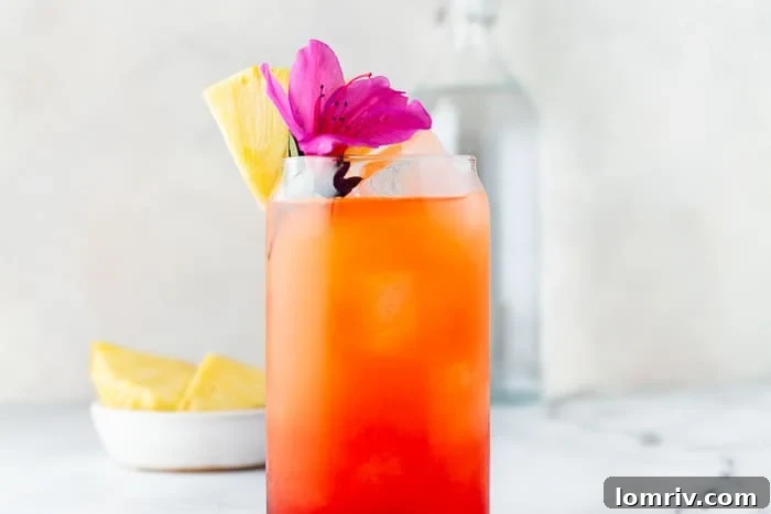 A perfectly mixed Pineapple Orange Rum Punch, garnished with pineapple and orange, ready to drink