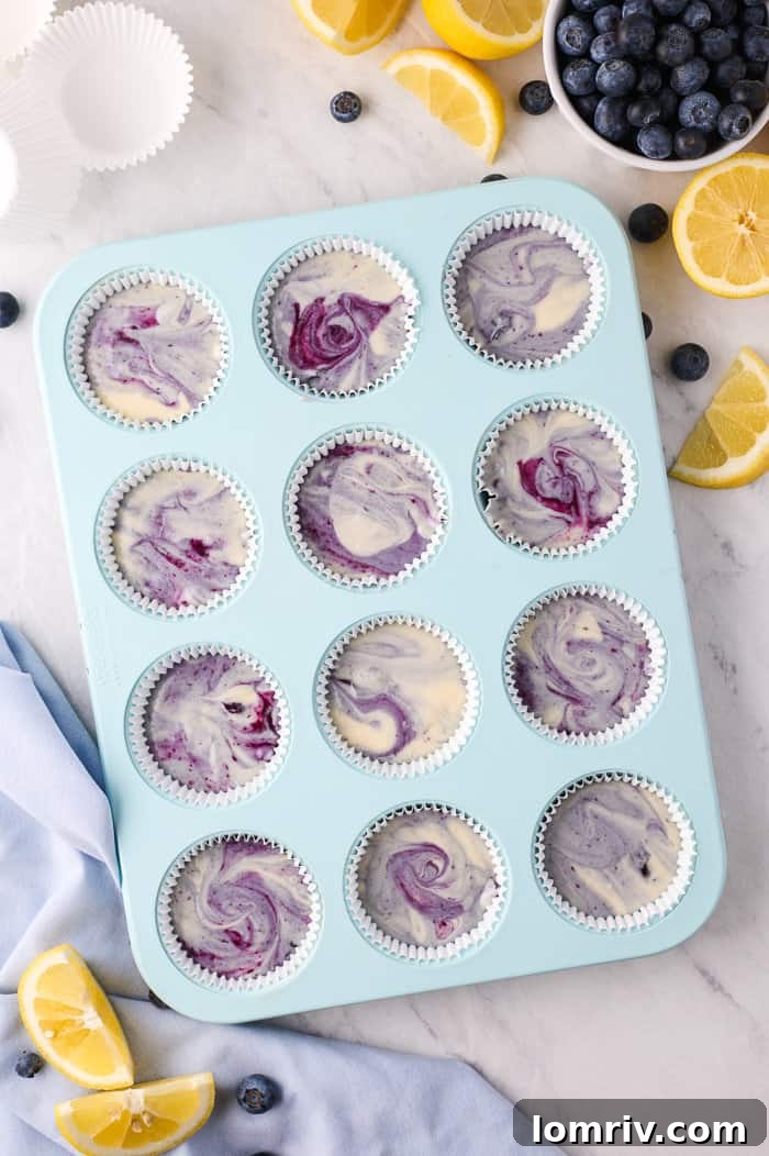 Cupcake batter in baking liners in a muffin tin
