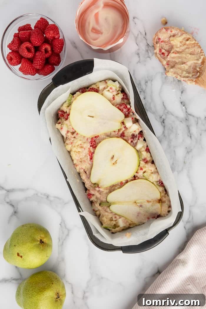 A freshly baked Pear and Raspberry Bread, perfectly golden, cooling on a wire rack.