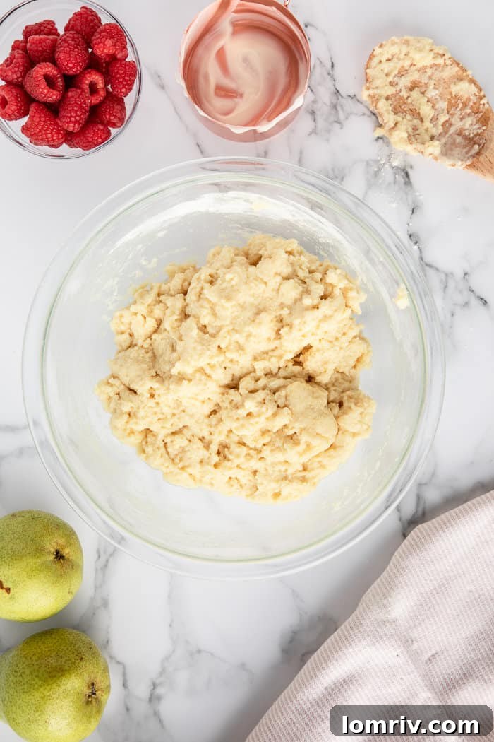 Diced pears and chopped raspberries being folded into the bread batter.