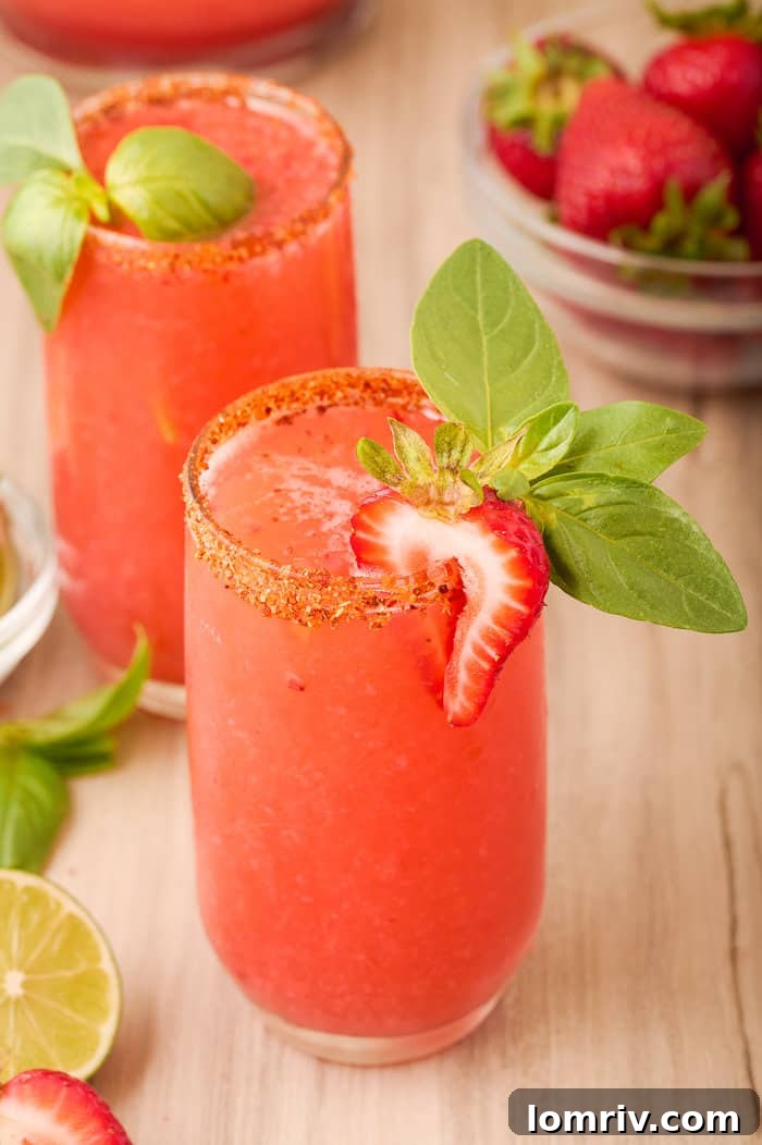 Ingredients for Strawberry Paloma laid out, emphasizing fresh strawberries and lime