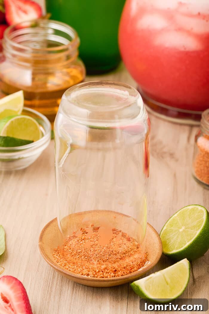 Rimming a glass with chili-lime salt for a Strawberry Paloma