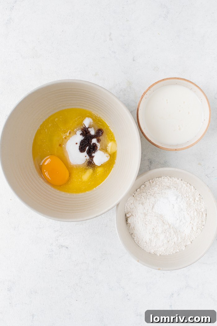 Wet ingredients (buttermilk, egg, butter, sugar, vanilla extract) being whisked together in a glass bowl.
