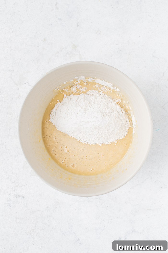 Cupcake batter in a bowl after combining wet and dry ingredients, with a spatula showing consistency.