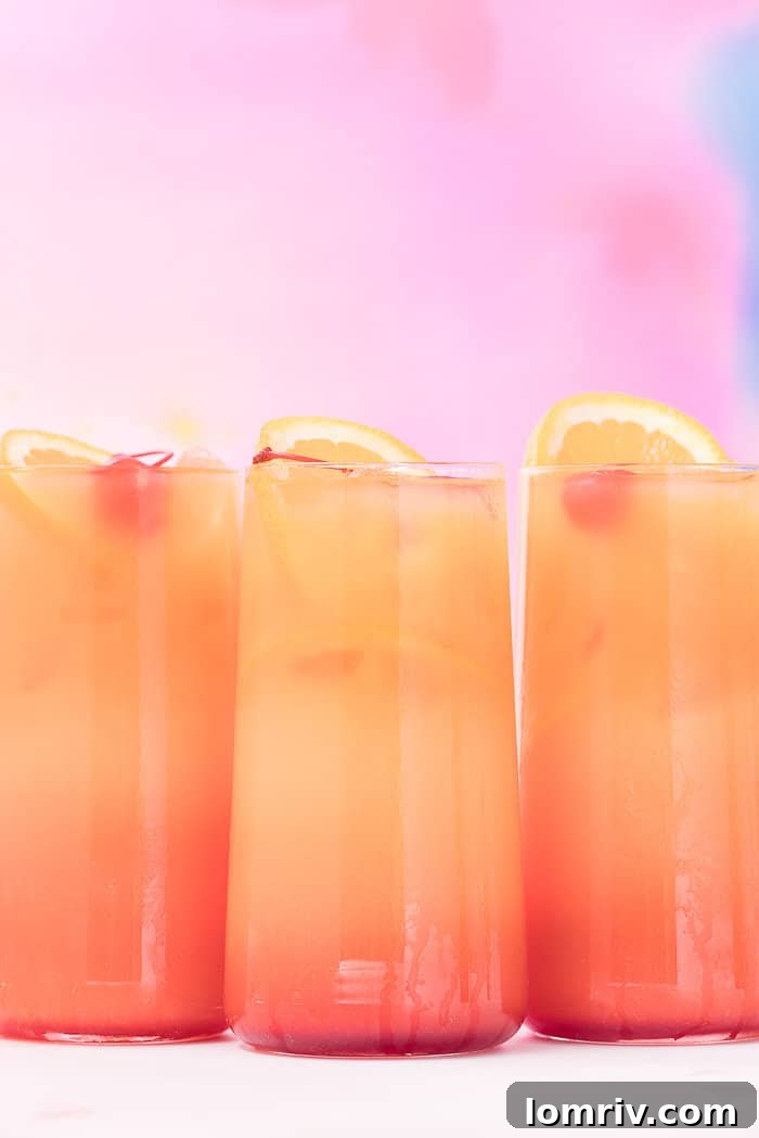Three glasses of Tequila Sunrise arranged artfully, emphasizing the striking visual appeal.