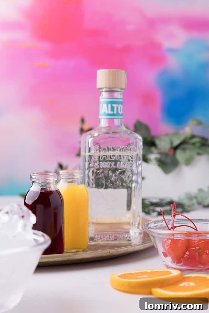 All the essential ingredients for making a classic Tequila Sunrise laid out on a table.