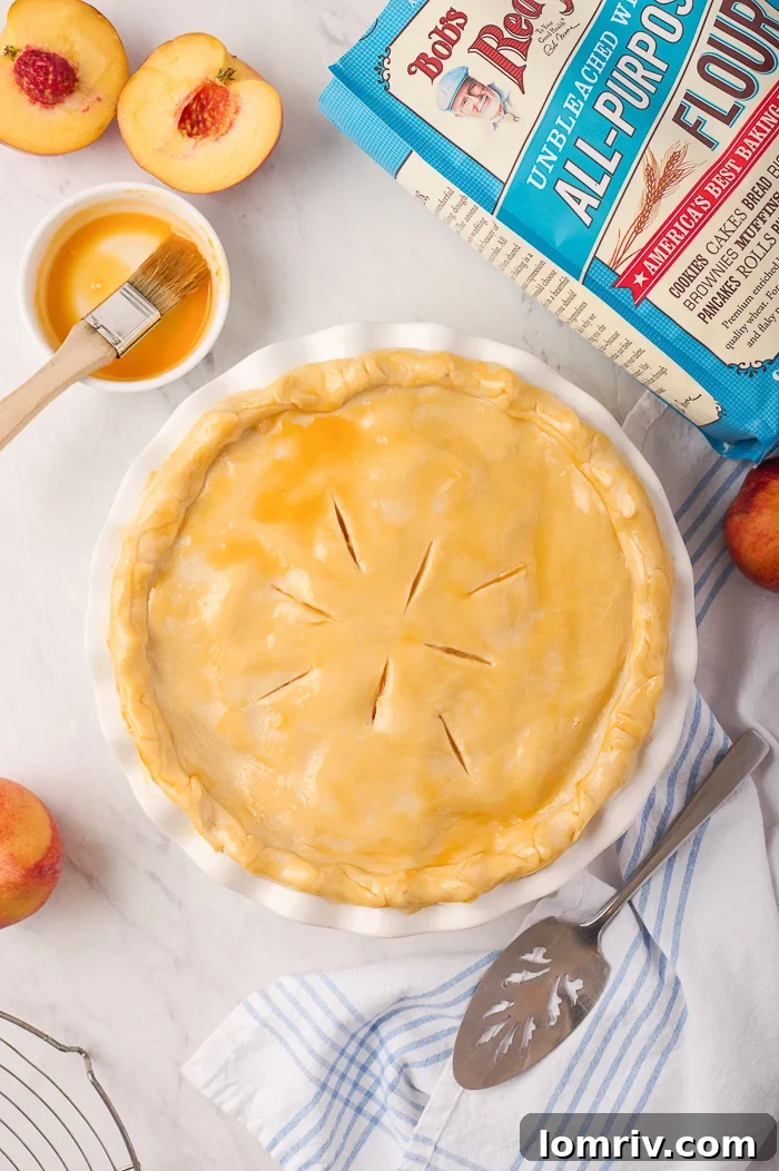 Serving of Fresh Peach Pie with a melting scoop of vanilla ice cream
