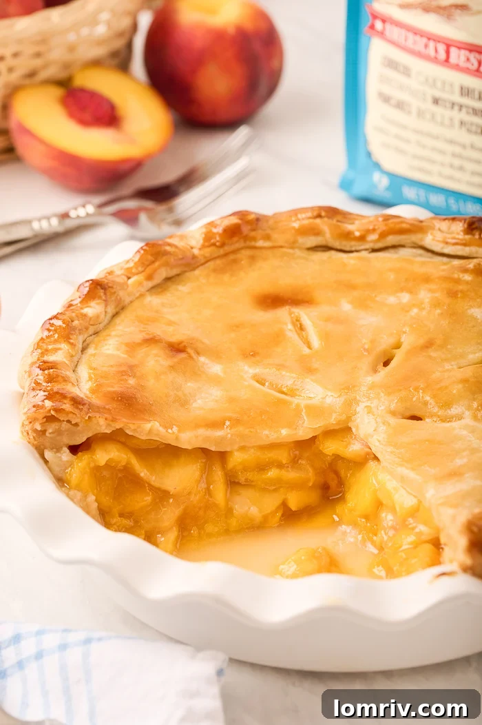 A delectable slice of Fresh Peach Pie on a white plate