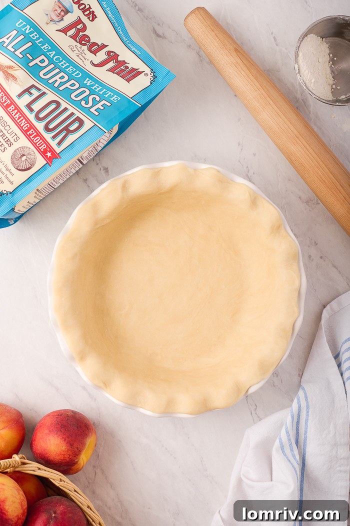 Artistically woven lattice top on a fresh peach pie before baking