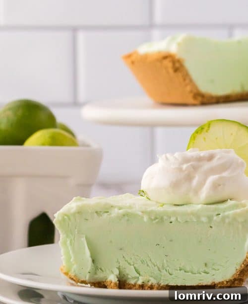 A slice of No Bake Key Lime Pie, showcasing its vibrant green filling and golden-brown graham cracker crust, ready to be enjoyed as a refreshing summer dessert.