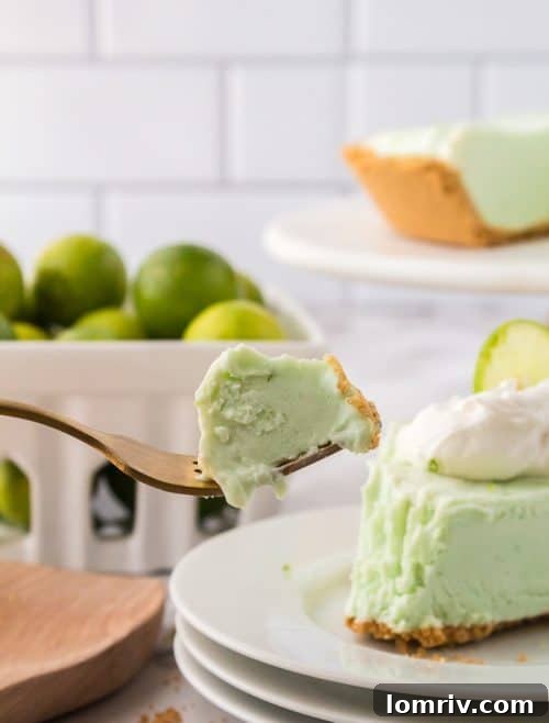 A beautiful, light green slice of No Bake Key Lime Pie, showing its smooth texture and a hint of crust, perfect for a refreshing treat.