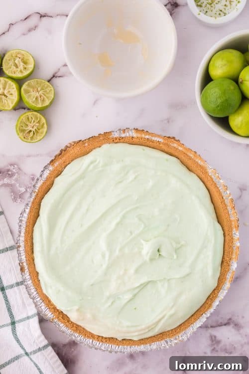 The No Bake Key Lime Pie filling has been poured into the graham cracker crust and is ready for chilling, highlighting the neat presentation.