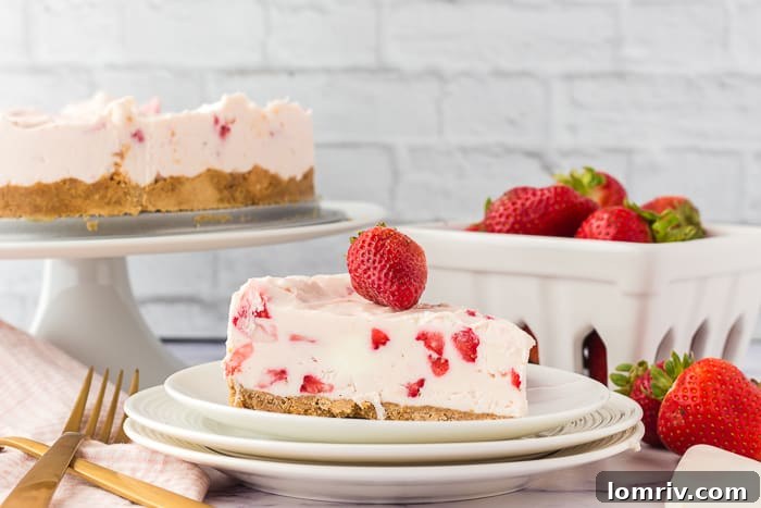 A close-up of a slice of no-bake strawberry cheesecake, showing its creamy layers and a firm crust.