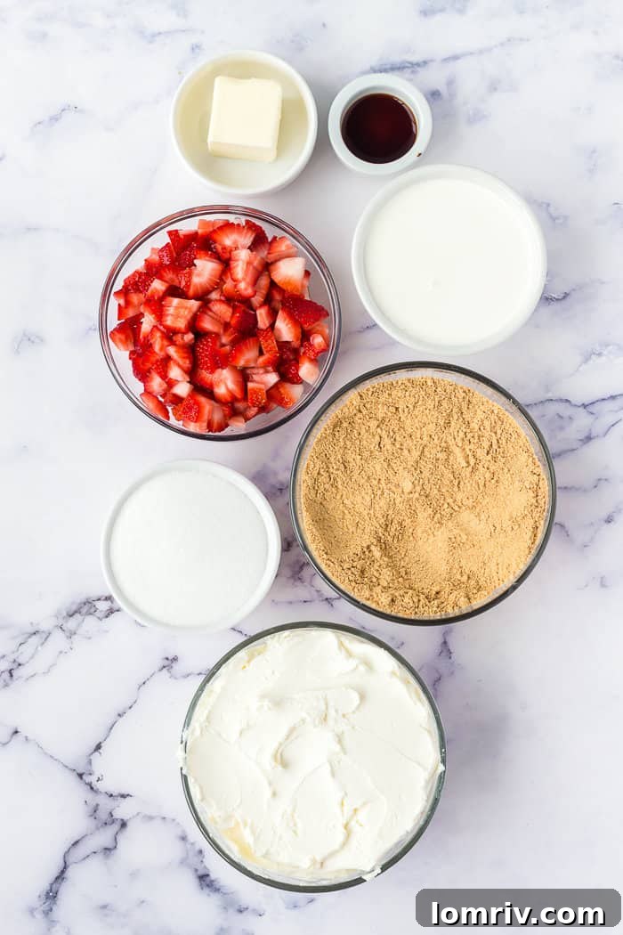 All the fresh and creamy ingredients laid out for making the no-bake strawberry cheesecake, including whole strawberries, cream cheese, and graham cracker crumbs.
