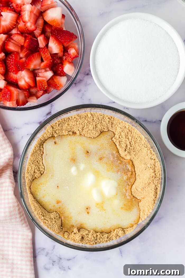 Melted butter being mixed into graham cracker crumbs in a bowl, forming the base for the cheesecake crust.
