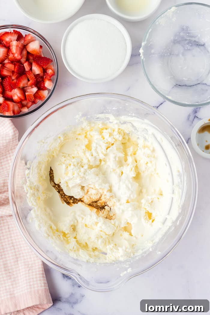 The smooth and creamy cheesecake filling, made with cream cheese, heavy cream, and vanilla extract, ready for the strawberries.