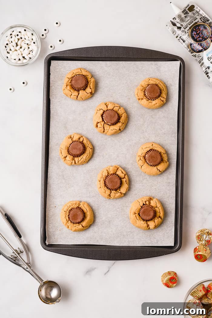 Pressing a Reese's cup into a warm cookie.