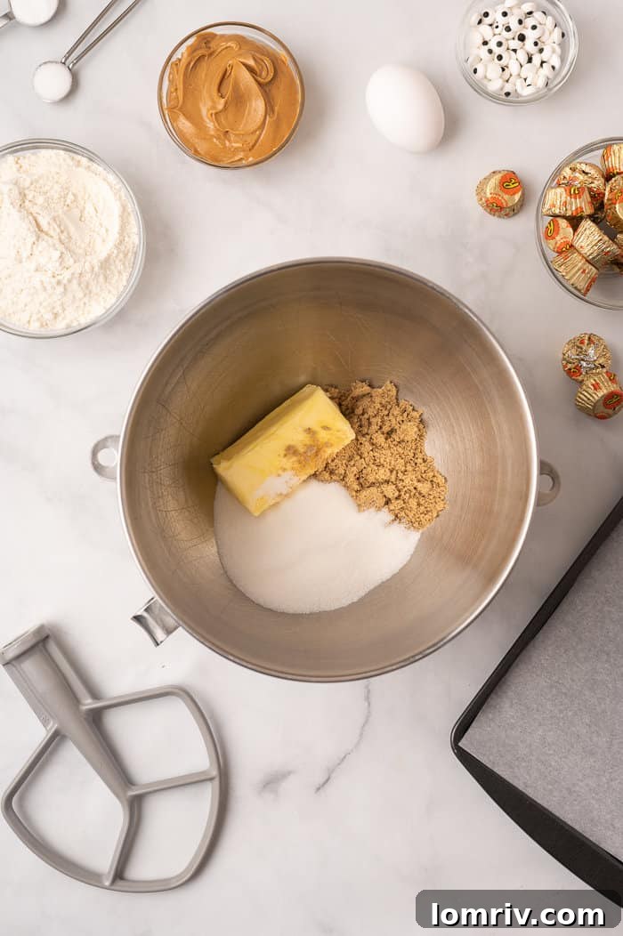 Butter and sugars in a mixing bowl for spider peanut butter cookies.