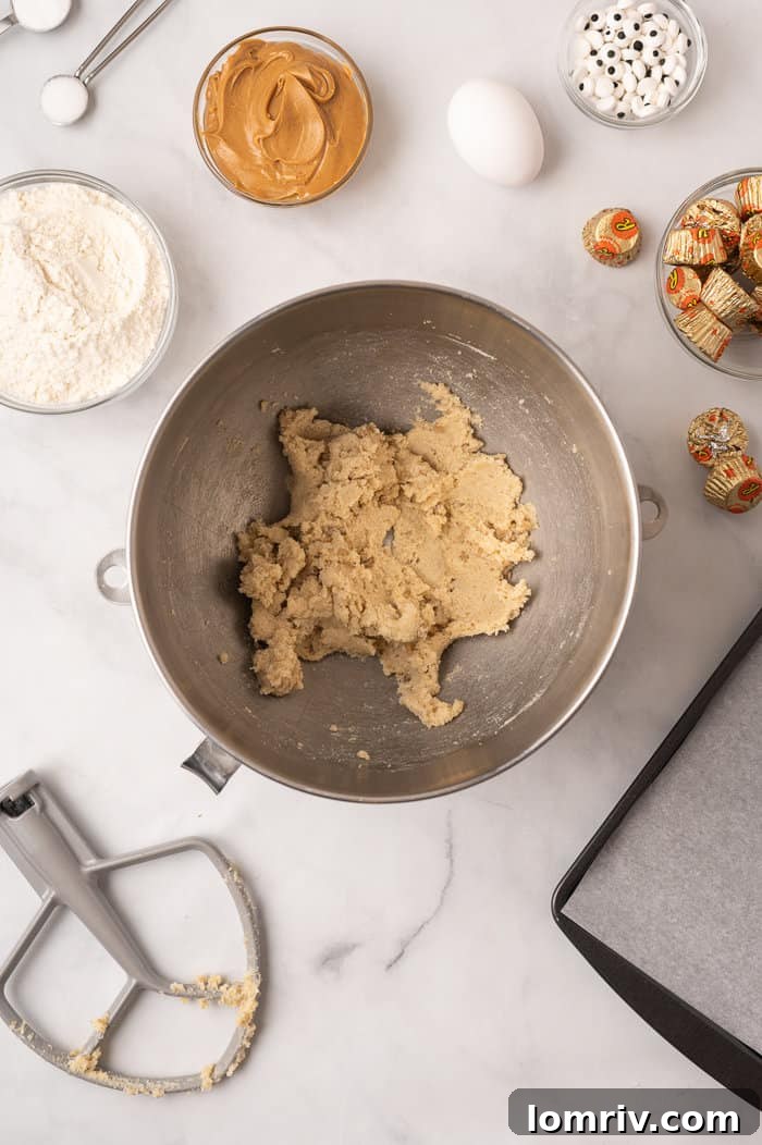 Beating butter and sugars with an electric mixer.