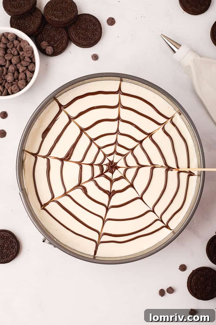 A toothpick being dragged through the concentric chocolate circles, creating the intricate and classic spider web pattern on the cheesecake.