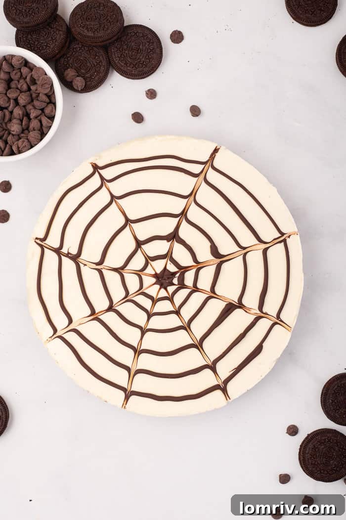 The fully chilled no-bake spider web cheesecake, perfectly set and ready to be sliced, showcasing its impressive Halloween design.