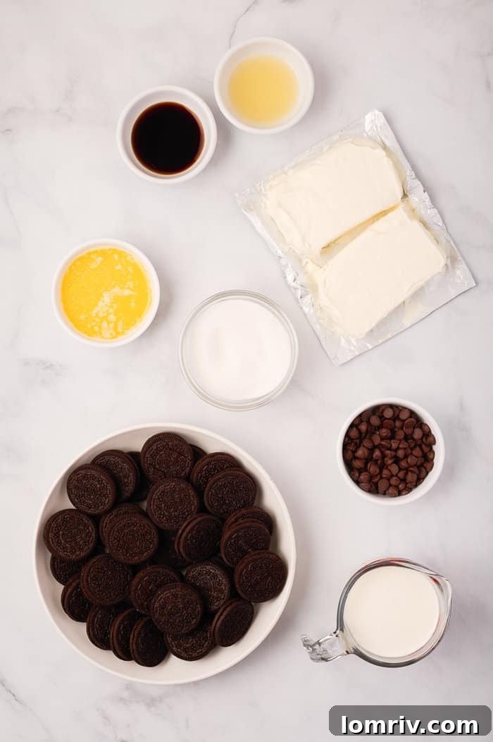 All the simple ingredients laid out for making the no-bake spider web cheesecake, including Oreos, butter, cream cheese, sugar, lemon juice, heavy cream, vanilla, and dark chocolate chips.