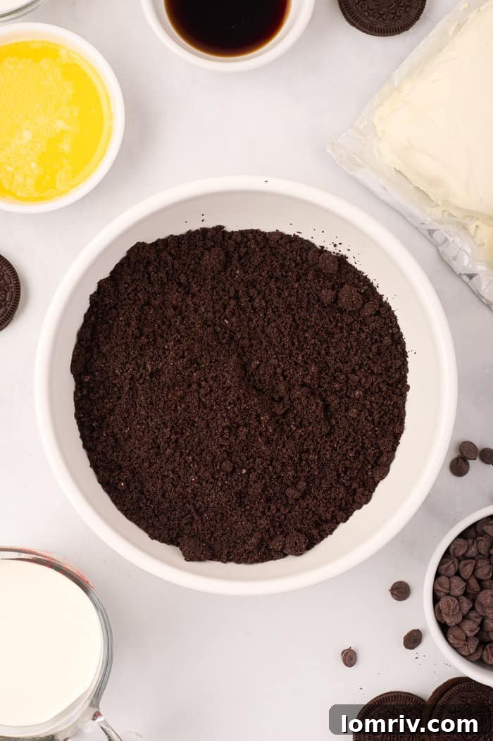 Melted butter being added to the crushed Oreo crumbs, a key step for creating the cheesecake's base.