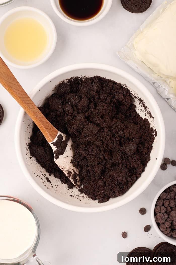 The perfectly pressed Oreo crust forming an even layer at the bottom of the springform pan, ready for the creamy cheesecake filling.