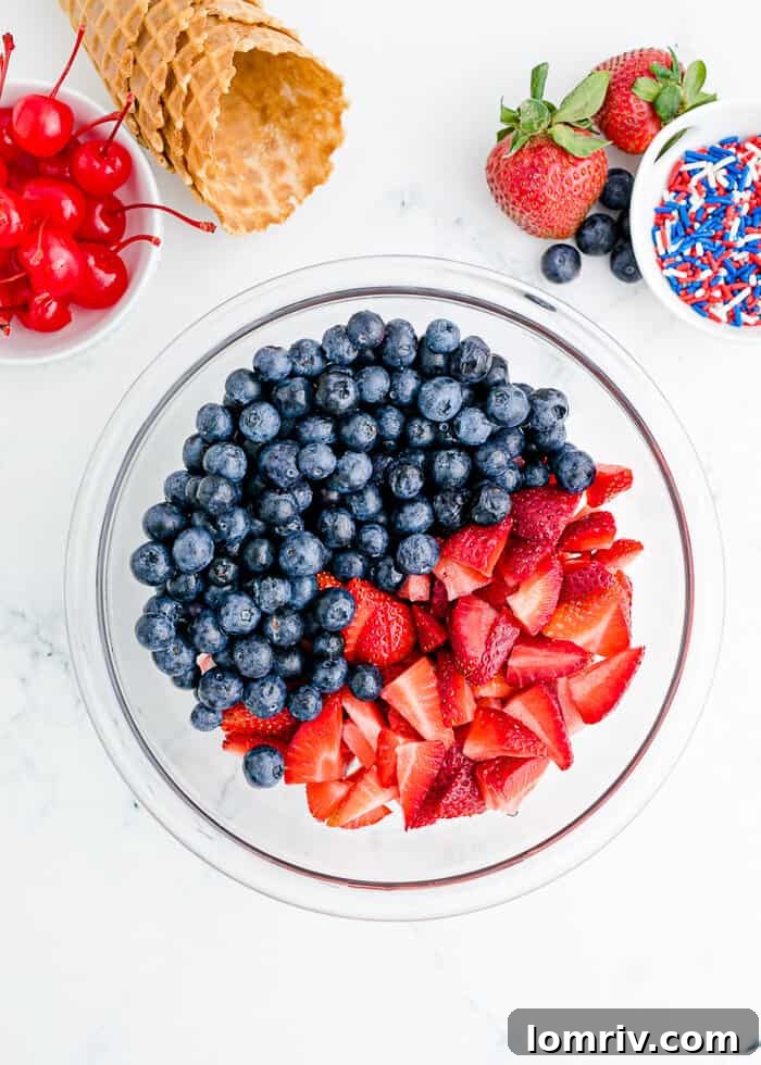 Sliced strawberries and blueberries mixed with sugar in a bowl, chilling.