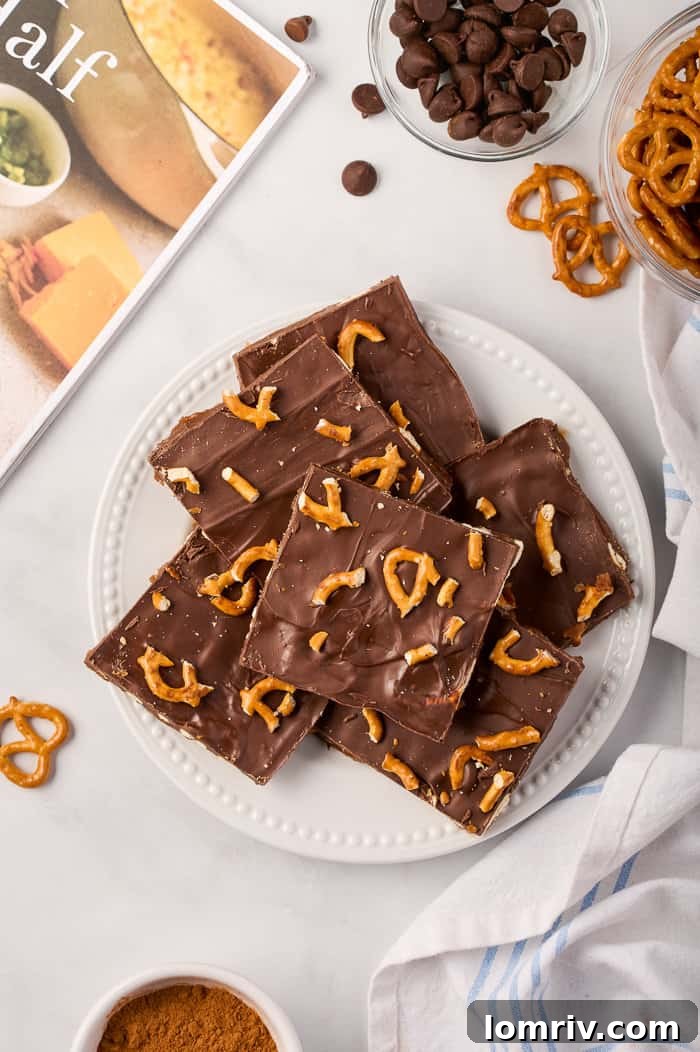 A plate of pumpkin bark, rich with chocolate, golden toffee, and crunchy pretzels, seasoned with pumpkin spice, ready to be enjoyed as a delightful fall treat.