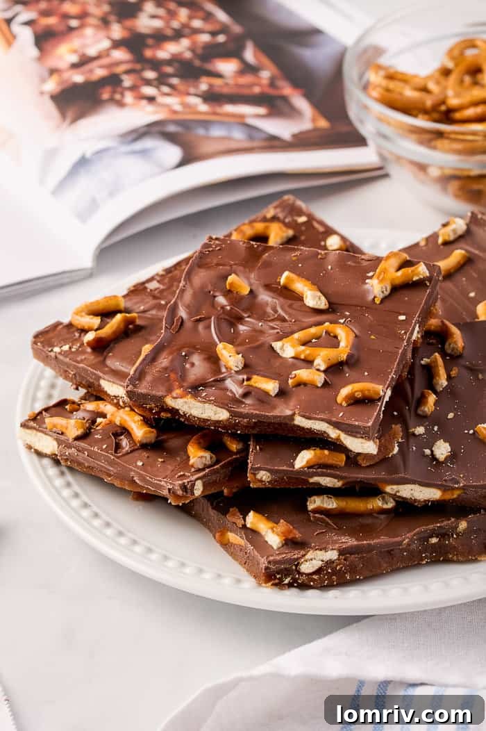 A close-up of pumpkin bark, showing the intricate layers of chocolate, pretzels, and spiced toffee, enticing with its texture and fall colors.