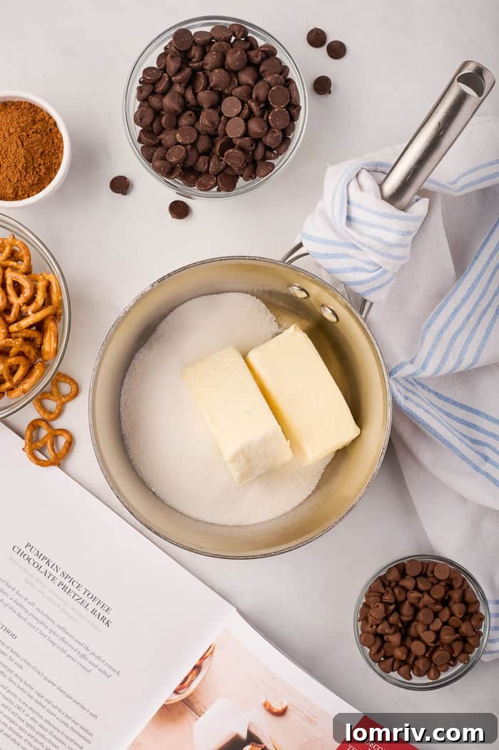 Ingredients for pumpkin bark, including butter, sugar, and salt, melting together in a heavy-bottomed pot on the stove.