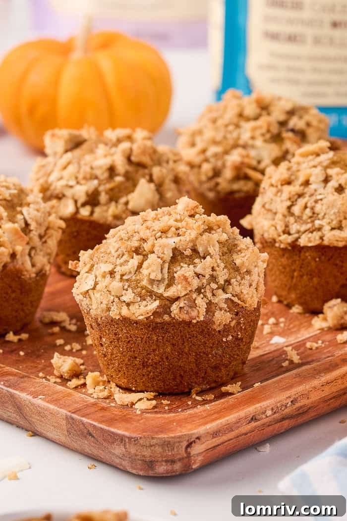 Close-up of golden brown pumpkin muffins on a rustic cutting board, showcasing their texture.