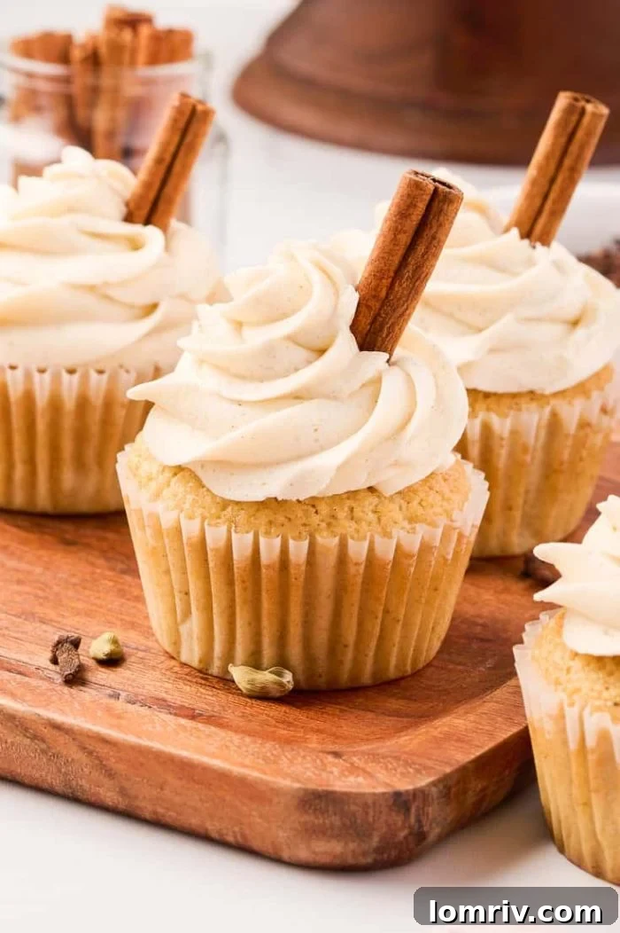 Delicious chai cupcakes, beautifully frosted and garnished, arranged on a rustic cutting board, inviting you to indulge in their warm, spiced flavor.