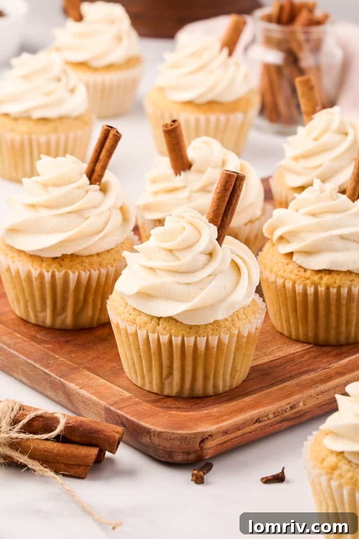 Freshly baked chai cupcakes cooling on a wire rack, glistening with their golden-brown tops.