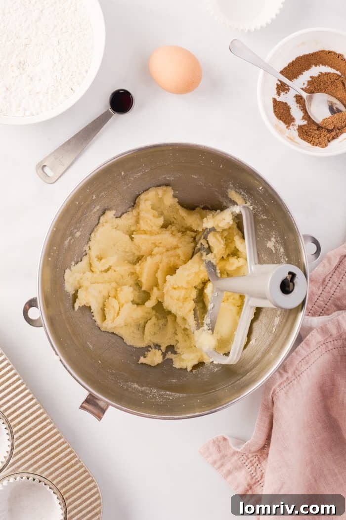 Butter and sugar are being creamed in a stand mixer, a crucial step for light and fluffy cupcakes.