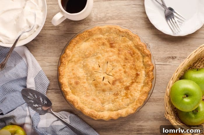 A freshly baked Maple Cream Apple Pie, golden and inviting, cooling on a wire rack.