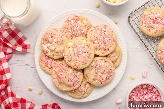 A stack of peppermint white chocolate cookies on a white plate, with a festive red and white pattern on the plate.