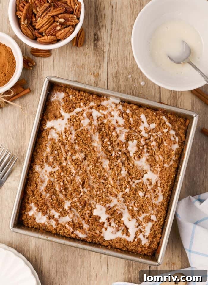 The finished sour cream coffee cake, beautifully drizzled with white icing, in the baking pan.