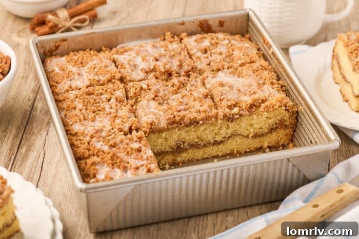 A baking pan filled with freshly baked sour cream coffee cake, expertly cut into individual servings.