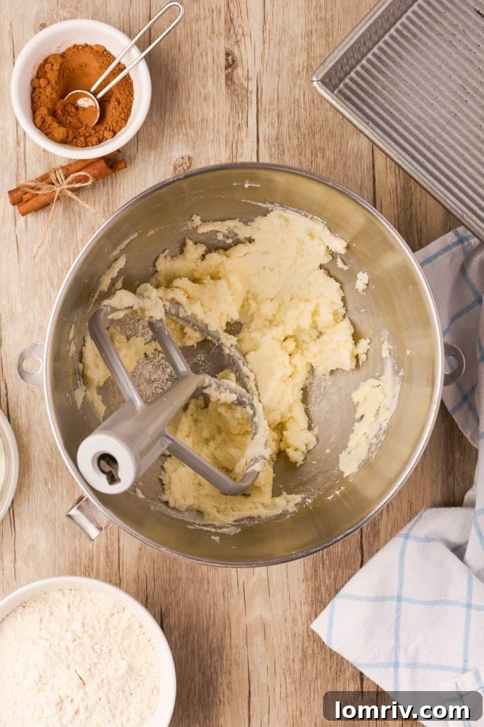 Butter and sugar being creamed together in a stand mixer, demonstrating the start of the cake batter preparation.