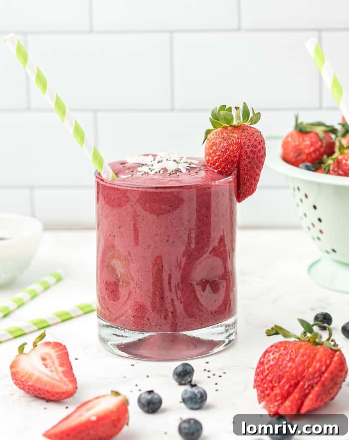 Pouring a creamy Very Berry Coconut Chia Smoothie into a glass