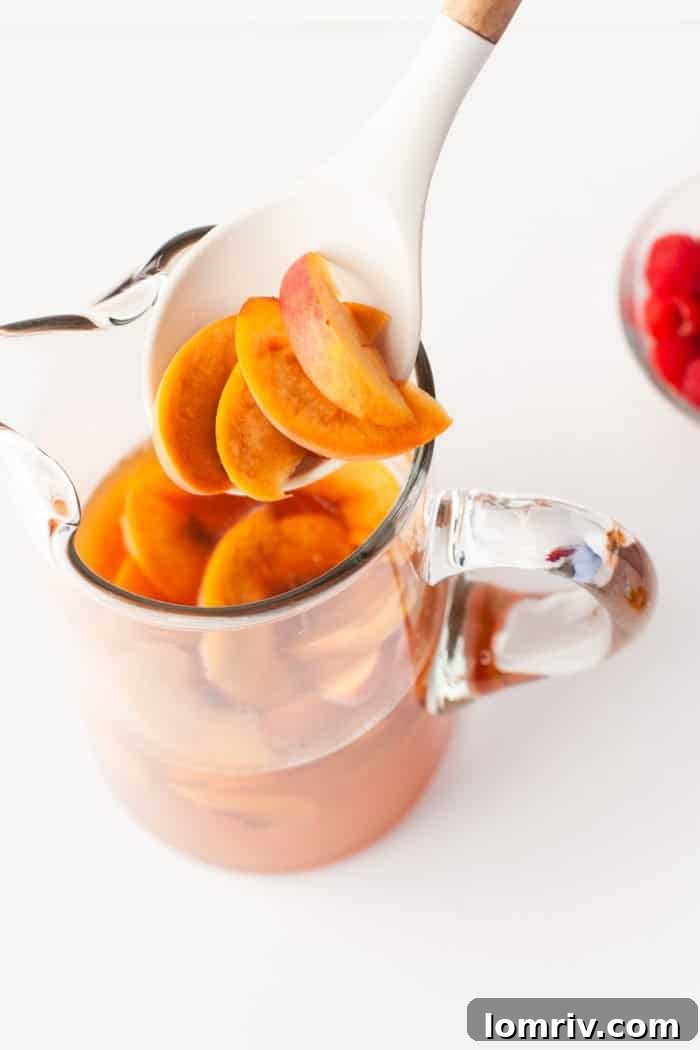 Adding peaches to peach sangria.