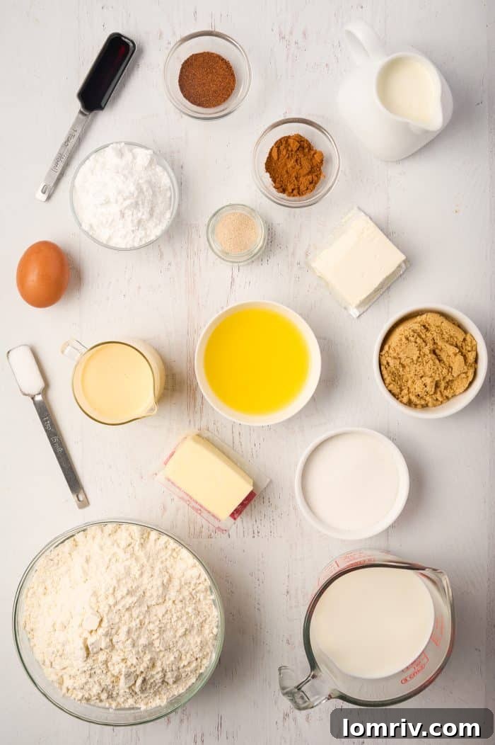 A collection of ingredients laid out for making Eggnog Cinnamon Rolls, including milk, eggs, flour, butter, and spices.