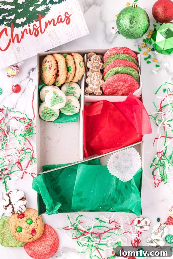 A close-up of a holiday cookie box being filled.