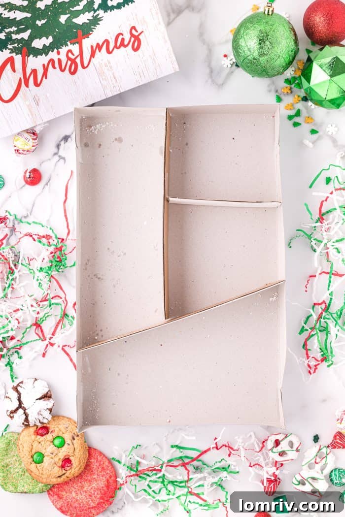 An empty holiday cookie box with cardboard dividers.