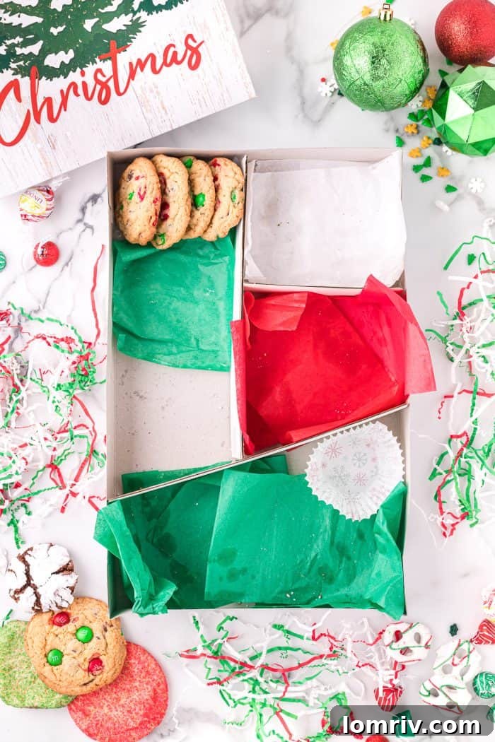 Placing various cookies into a holiday cookie box.