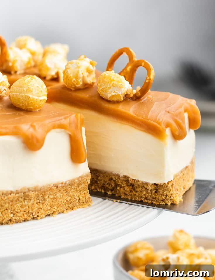 A slice of no-bake caramel cheesecake being carefully removed from a whole cake on a stand, showcasing its creamy layers and toppings.