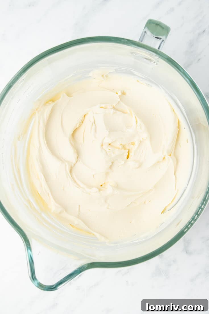 The smooth, creamy no-bake cheesecake filling being prepared in an electric stand mixer, showing its rich texture.