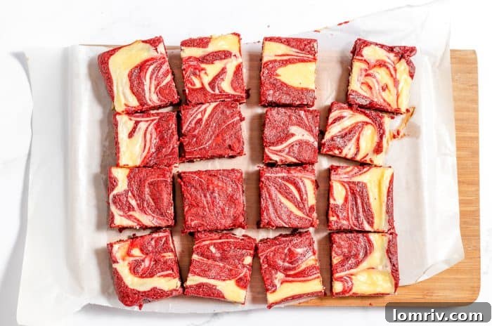 Perfectly sliced red velvet cheesecake brownies, showcasing the beautiful swirl.